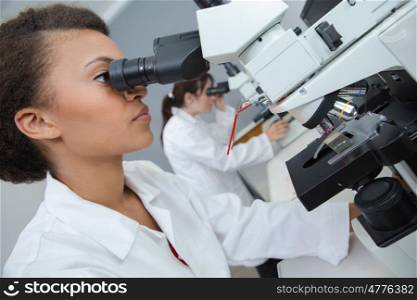 beautiful scientist looking through a microscope