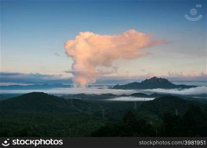 Beautiful sea of fog in the mountains, high voltage pole and steam from the coal power plant in the morning sunrise . Mae moh, Lampang, Thailand. Energy and environment concept .. Sea of fog and coal power plant.