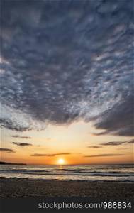 Beautiful sea sunset or sunrise with amazing clouds. Vertical view