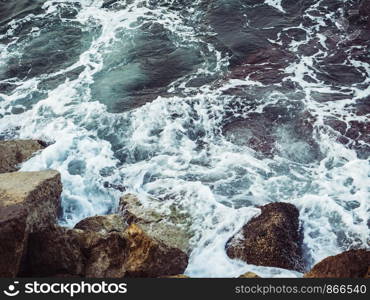 Beautiful sea surf, stormy waves and rocks. View from above. Close-up. Beautiful sea surf, stormy waves and rocks
