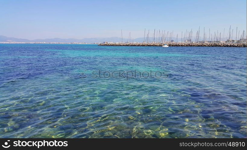 Beautiful sea views with transparent turquoise water, yachts and Palma de Mallorca on the horizon. L'Arenal, Majorca, Balearic Islands, Spain.