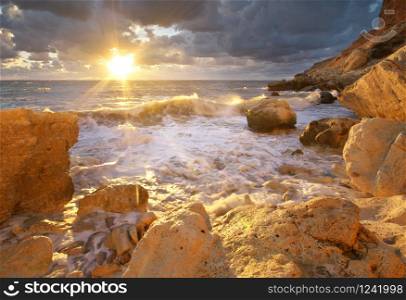 Beautiful seascape. Sea waves during storm on sunset splash on stones. Composition of nature.