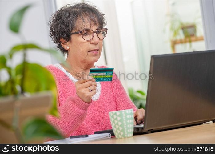 beautiful senior brunette woman shopping with internet
