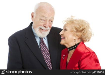 Beautiful senior couple dressed for the holidays, giving each other a knowing look of romance. Isolated.