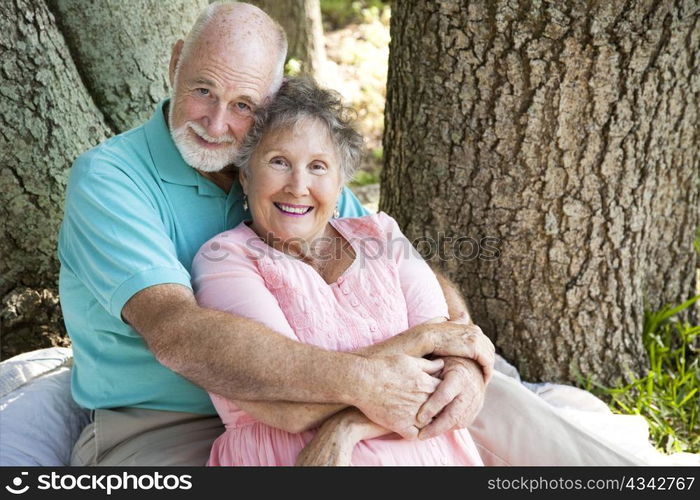 Beautiful senior couple in love, embracing under a tree.