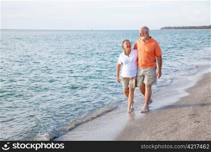 Beautiful senior couple takes a romantic stroll on a tropical beach.