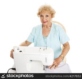 Beautiful senior woman enjoys sewing. Isolated on white.