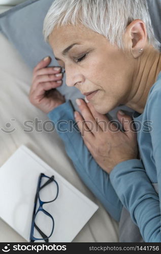 Beautiful Senior Woman Sleeping Peacefully After Reading a Book