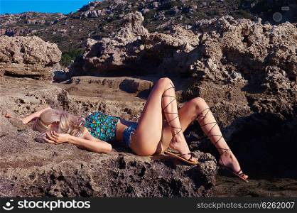 Beautiful sensual blonde in a greek sandals at the seashore. Summer travel fashion photo