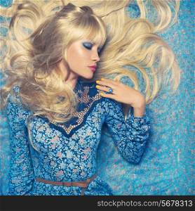 Beautiful sensual blonde lying on a blue pattern