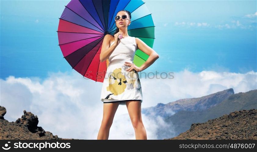 Beautiful sensual brunette holding colorful umbrella