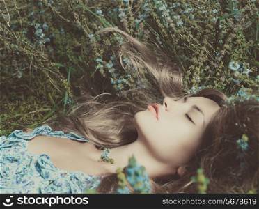 Beautiful sensual lady lying on flower meadow
