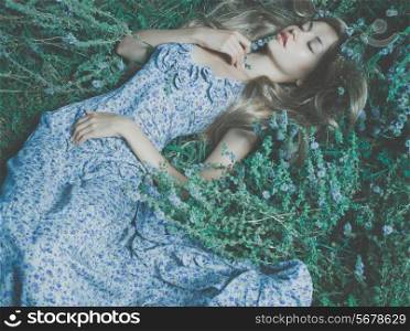 Beautiful sensual lady lying on flower meadow