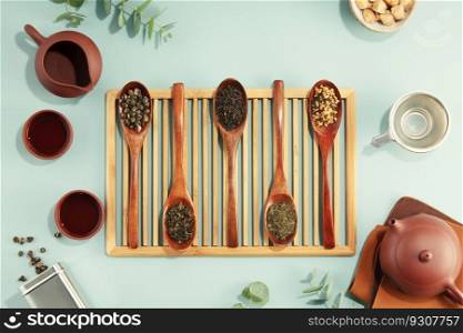 Beautiful set for traditional tea ceremony and tea collection in wooden spoons on light blue background flat lay. Beautiful set for traditional tea ceremony and tea collection in wooden spoons on light blue background