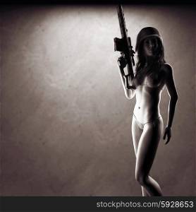 Beautiful sexy bikini woman holding army weapon