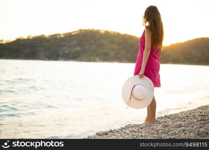 beautiful sexy girl in a pink dress  resting on the beach at sunset