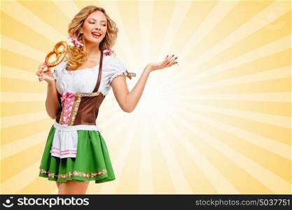 Beautiful sexy Oktoberfest woman wearing a traditional Bavarian dress dirndl posing with a soft salty pretzel on colorful abstract cartoon style background.