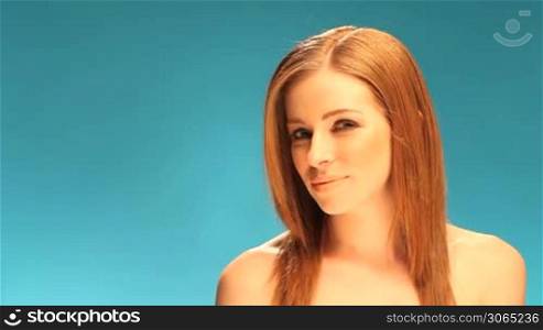 Beautiful Sexy Redhead Portrait head and shoulders implied topless on blue background