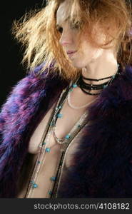 Beautiful sexy redhead woman with feather coat and jewelry, over black