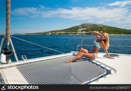 beautiful sexy woman in swimwear relaxing on a yacht front at hot∑mer day. beautiful sexy woman in swimwear relaxing on a yacht front