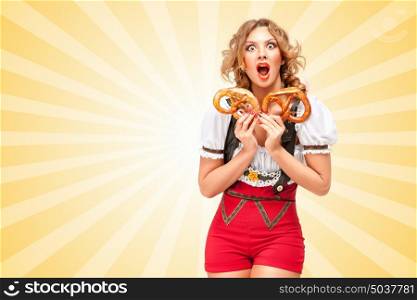 Beautiful sexy woman wearing red jumper shorts with suspenders in a form of a traditional dirndl, holding with hunger two pretzels on colorful abstract cartoon style background.