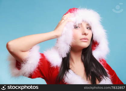 Beautiful sexy woman wearing santa claus costume clothes on blue background