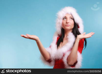 Beautiful sexy woman wearing santa claus costume clothes showing empty copy space for product presenting with open hand palm on blue background