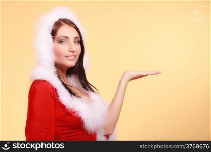 Beautiful sexy woman wearing santa claus costume clothes showing empty copy space for product presenting with open hand palm on yellow background