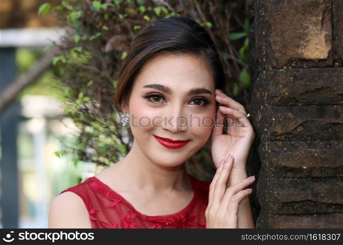 Beautiful sexy young business woman brunette hair with evening make-up wearing a red skinny dress and high-heeled shoes business clothes for meetings and walks fall collection perfect body shape.