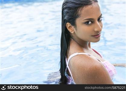 Beautiful sexy young Indian Asian woman or girl wearing bikini in swimming pool