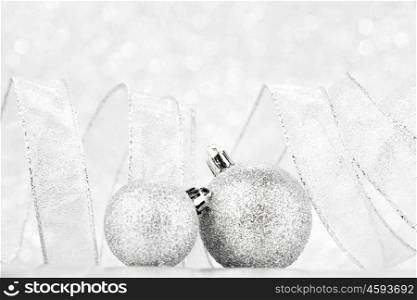 Beautiful silver christmas balls on abstract glitter background close-up
