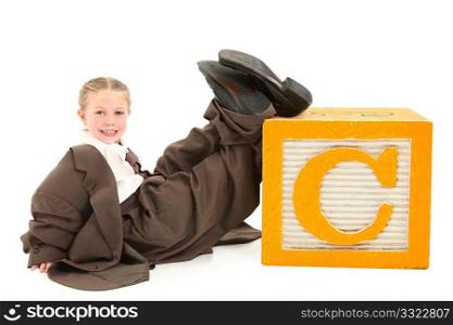 Beautiful six year old american girl in over sized suit with the letter C.