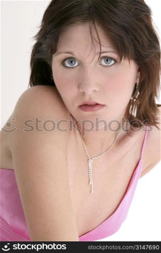 Beautiful sixteen year old girl in pink formal or prom dress. Dark hair and blue eyes.