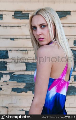 Beautiful slender blonde against a peeling wall
