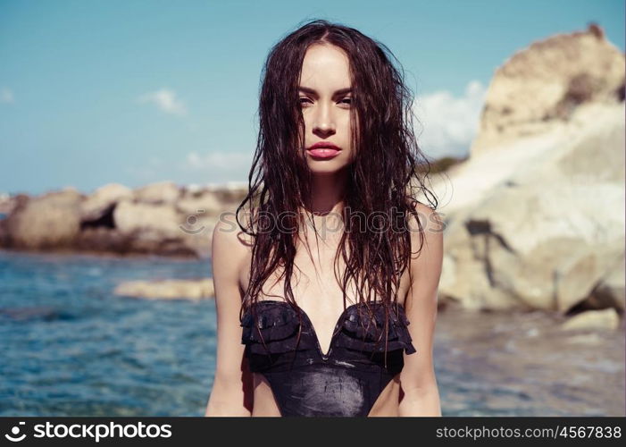 Beautiful slender brunette at the sea. Summer travel photos