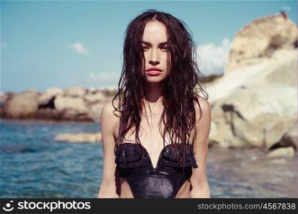 Beautiful slender brunette at the sea. Summer travel photos