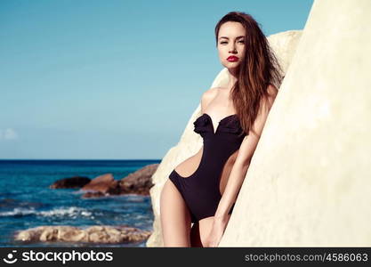 Beautiful slender brunette at the sea. Summer travel photos