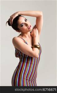 Beautiful slender young brunette in a tight striped dress