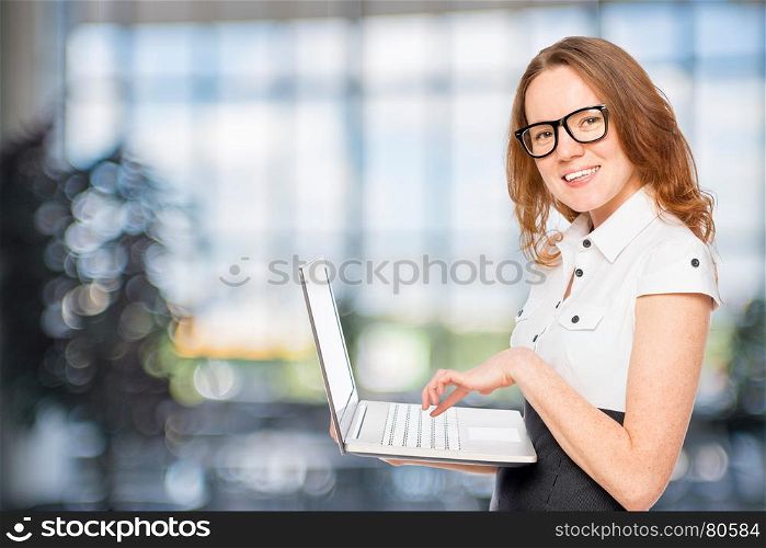 beautiful slim secretary with a laptop in the office