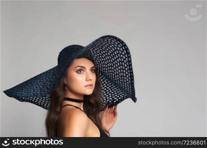 Beautiful, slim woman with big and large summer hat in alluring underwear.Sexy lady in lingerie.Fashion portrait of model indoors.. Beautiful, slim woman posing with big hat