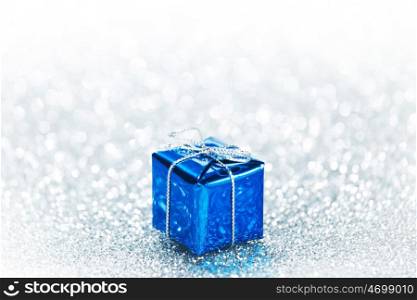Beautiful small blue holiday gift box on silver glitters