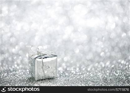 Beautiful small holiday gift box on silver glitters