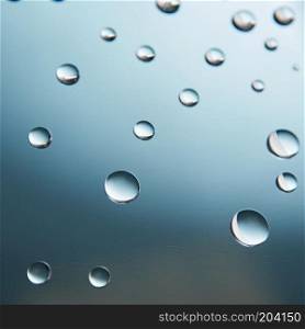 Beautiful small water drops on the glass on blue gradient background. small water drops on the glass on blue gradient background