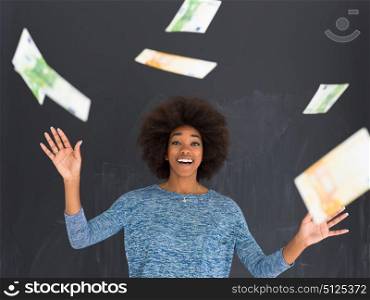 beautiful smiling afro american woman throwing money isolated on a gray background