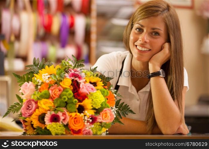 Beautiful smiling florist in her store with colorful bouquet