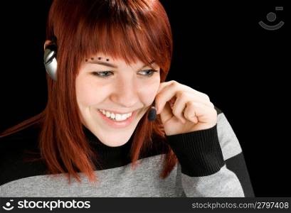 Beautiful smiling girl at a call center answering with a handset. Studio shot.