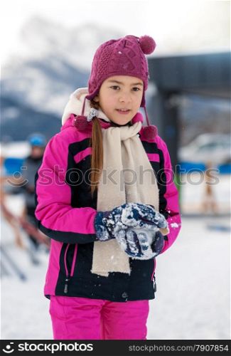 Beautiful smiling girl posing on top mountain covered by snow