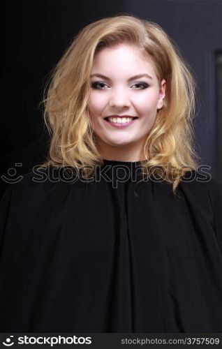 Beautiful smiling girl with blond wavy hair by hairdresser. Happy young woman in hairdressing beauty salon. Hairstyle.