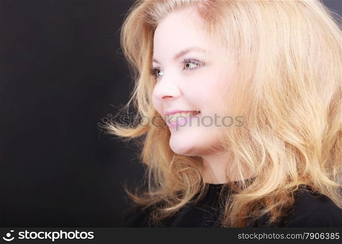 Beautiful smiling girl with blond wavy hair by hairdresser. Happy young woman in hairdressing beauty salon. Hairstyle.