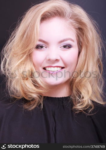 Beautiful smiling girl with blond wavy hair by hairdresser. Young woman in hairdressing beauty salon. Hairstyle.